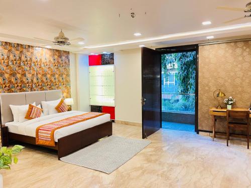 a bedroom with a bed and a desk in a room at South Haven Residency - South Extension South Delhi in New Delhi