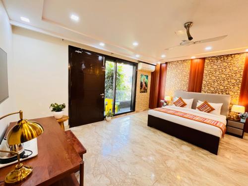a bedroom with a bed and a desk with a lamp at South Haven Residency - South Extension South Delhi in New Delhi