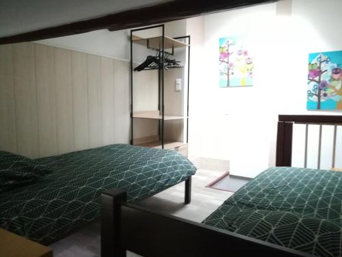 a bedroom with a bed with a green comforter at Maisonnette atypique du centre ville in Pont-à-Mousson