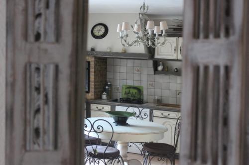 a kitchen with a table and chairs and a clock at Gîtes maisons de vacances Domaine la Chamade Carpentras in Carpentras
