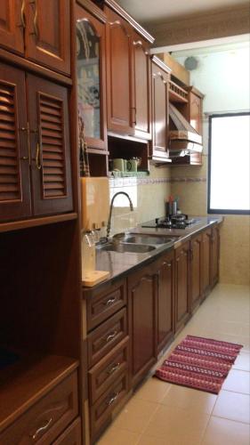 a kitchen with wooden cabinets and a sink at Double Storey Terrace House in Perai