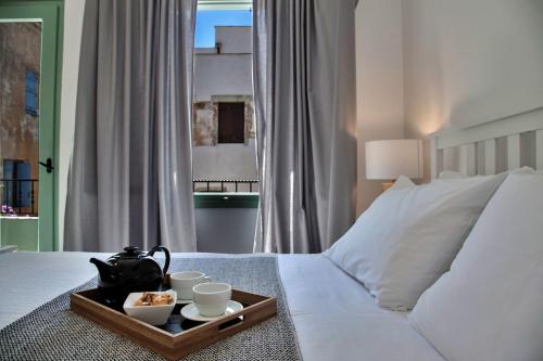 Una cama blanca con una bandeja de comida. en Old town, Splantzia modern house, en La Canea