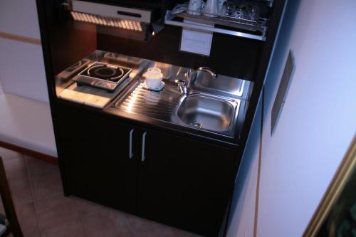 a small kitchen with a sink in a refrigerator at Ca' Del Sasso in Verona