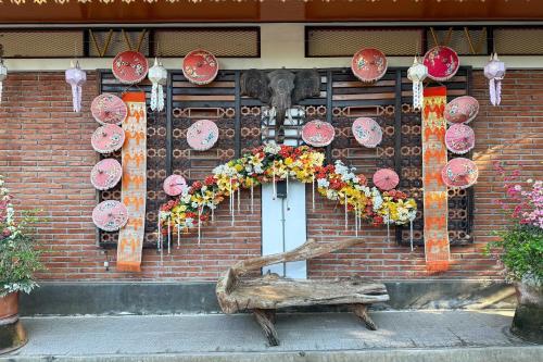 a brick building with a heart made out of flowers at Chiangmai Lanna & Modern Loft Hotel in Ban Mae Pu Kha