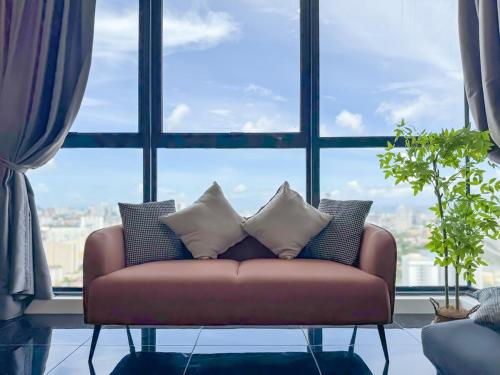a couch in a room with a large window at Panoramic Georgetown City & Sea View with Netflix in Jelutong