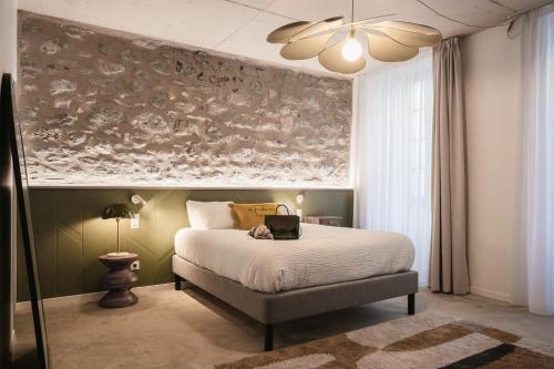 a bedroom with a bed with a laptop on it at Maison des Cassiers By Les Fleurines in Villefranche-de-Rouergue