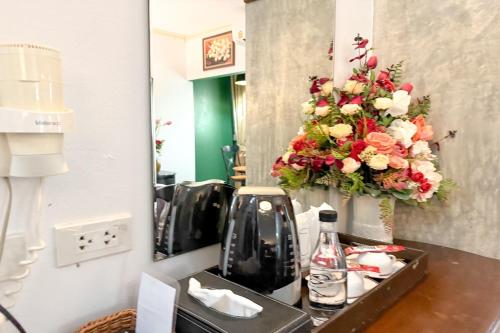 a vanity with a flower arrangement in a mirror at Chiangmai Lanna & Modern Loft Hotel in Ban Mae Pu Kha