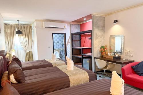 a hotel room with two beds and a red chair at Chiangmai Lanna & Modern Loft Hotel in Ban Mae Pu Kha