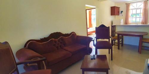 a living room with a couch and a table at Costambar Ocean Breeze - Beachfront Apartment with Pool in Las Flores