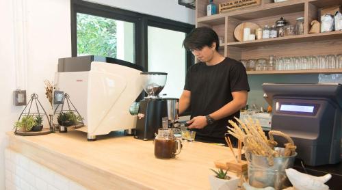 a man standing at a counter with a blender at Shade House - Bitec Bangna in Bangkok