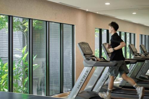 a man running on a treadmill in a gym at Hotel Royal Beitou in Taipei