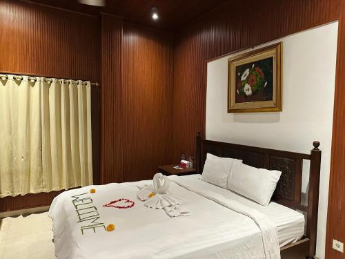 a bedroom with a large bed with white sheets at Puri Jumpungan Villas in Sidemen