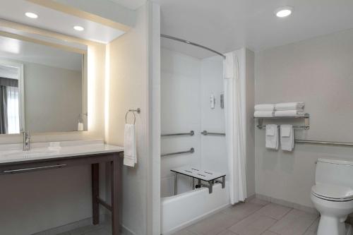 a bathroom with a toilet and a sink and a mirror at Homewood Suites by Hilton Tallahassee in Tallahassee