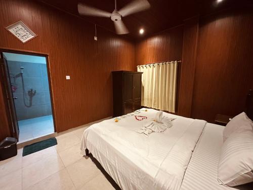 a bedroom with a bed and a bathroom with a shower at Puri Jumpungan Villas in Sidemen