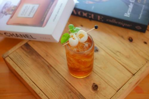 a drink sitting on a table next to a book at Up-Peak Hotel Simpang Lima Semarang Formerly HA-KA Simpanglima Hotel Semarang in Semarang