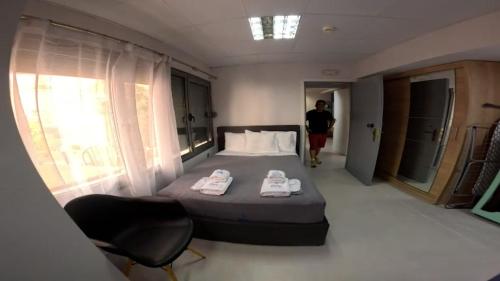 a bedroom with a bed and a person walking into a room at DATA Maisonettes and more in Chios