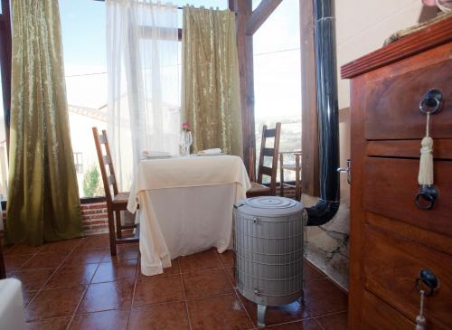 ein Esszimmer mit einem Tisch und einer Heizung in der Unterkunft Hotel Rural El Yantar de Gredos in San Martín del Pimpollar