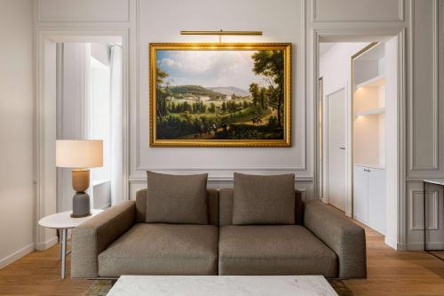 a living room with a couch and a painting on the wall at Dolce by Wyndham Versailles - Domaine du Montcel in Jouy-en-Josas