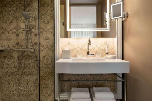 a bathroom with a white sink and a shower at Dolce by Wyndham Versailles - Domaine du Montcel in Jouy-en-Josas