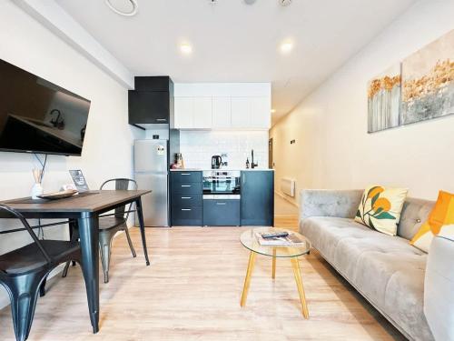 a living room with a couch and a table and a kitchen at Central Location Cozy Studio with Pool Gym & Sauna Nearby Skytower in Auckland