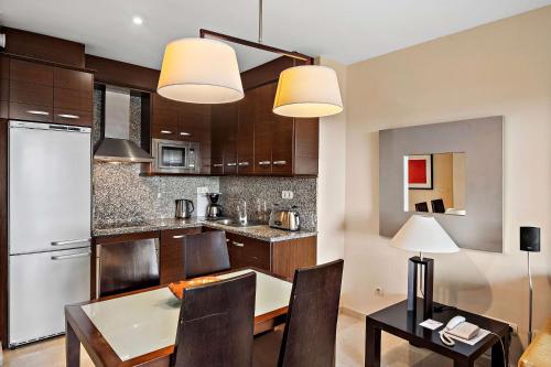 a kitchen with a table and chairs and a dining room at Wyndham Grand Costa del Sol in Mijas Costa