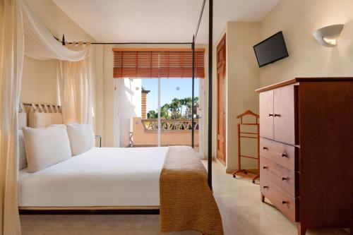 a bedroom with a large white bed and a window at Wyndham Grand Costa del Sol in Mijas Costa