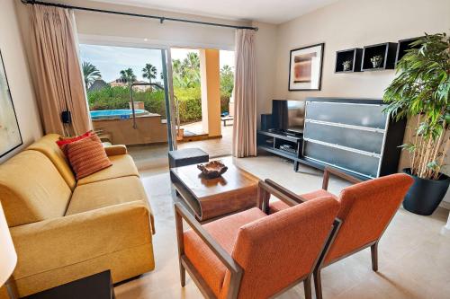 a living room with a couch and a tv at Wyndham Grand Costa del Sol in Mijas Costa