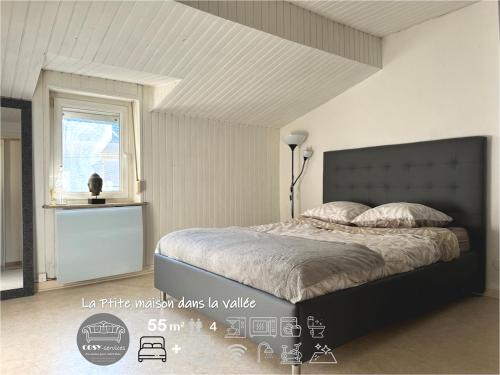 une chambre avec un grand lit et une fenêtre dans l'établissement LaPetite Maison dans la vallée, à Hayange