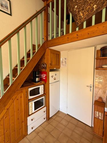 une cuisine avec un escalier menant à un loft dans l'établissement Horizon Bleu, à Leucate-Plage