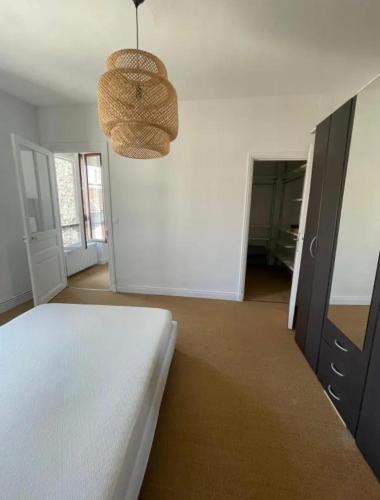 une chambre avec un lit et un lustre dans l'établissement 2 bedroom Apartment Reims, à Reims