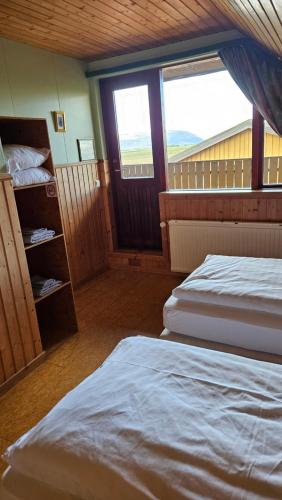 two beds in a room with two windows at Árnanes Country Hotel in Höfn