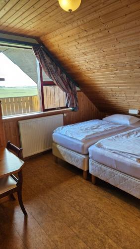 two beds in a room with a wooden ceiling at Árnanes Country Hotel in Höfn