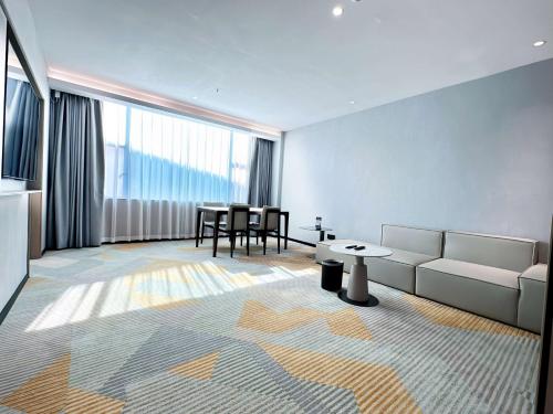 a living room with a couch and a table at Hawthorn by Wyndham Guangzhou Baiyun Airport in Guangzhou