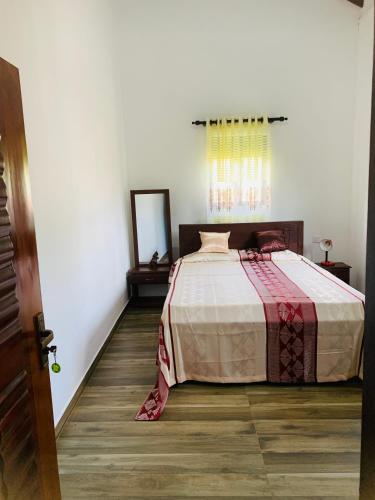 a bedroom with a bed in a room with a window at Malinga homes in Wennappuwa