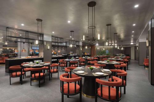 a restaurant with tables and chairs and a bar at Ramada by Wyndham Zhuhai Xiangzhou in Zhuhai
