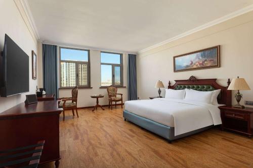 a large hotel room with a bed and a desk at Days Hotel by Wyndham Harbin Qunli in Harbin