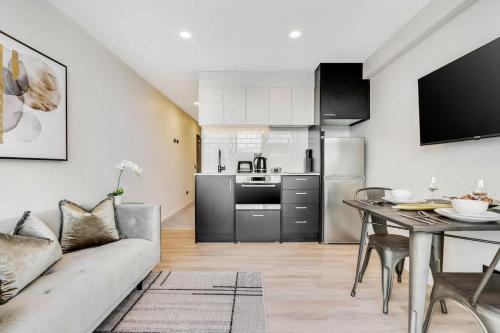 a living room with a couch and a table at High Level Stylish Studio Apartment City Central - Pool Gym Sauna in Auckland