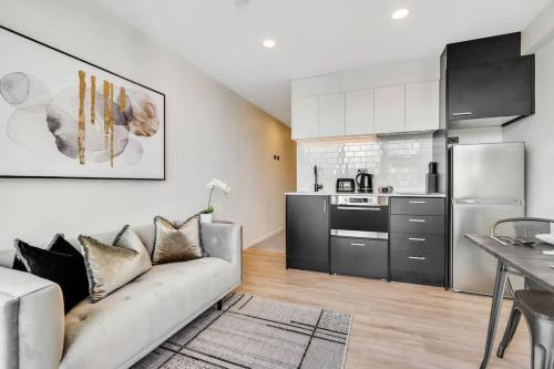 a living room with a couch and a kitchen at High Level Stylish Studio Apartment City Central - Pool Gym Sauna in Auckland