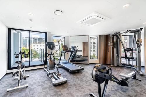 a gym with several treadmills and machines in a room at High Level Stylish Studio Apartment City Central - Pool Gym Sauna in Auckland