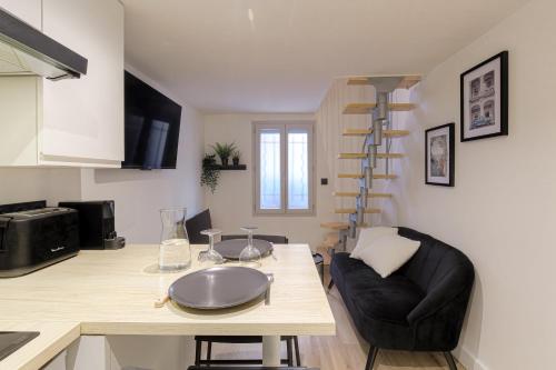 - un salon avec une table et un escalier en colimaçon dans l'établissement City-duplex, à Lyon