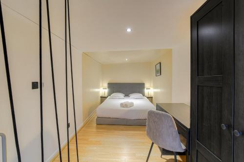 une chambre avec un lit et un bureau avec une chaise dans l'établissement City-duplex, à Lyon