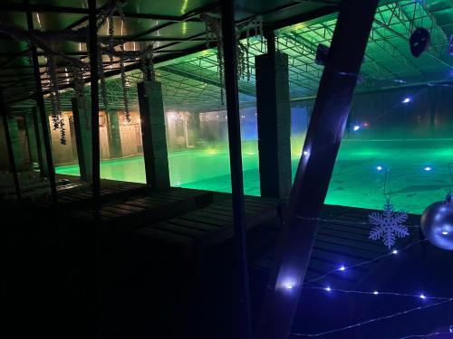 an empty swimming pool at night with green lights at Khatky Na Penkakh in Vorokhta
