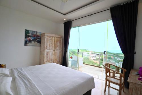 une chambre avec un lit et une grande fenêtre dans l'établissement Villa Aventus Uluwatu, à Uluwatu
