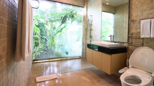 une salle de bain avec toilettes, lavabo et fenêtre dans l'établissement Villa Aventus Uluwatu, à Uluwatu
