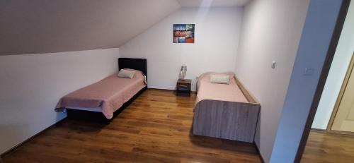 ヴィシェグラードにあるApartman Dan & Nocのウッドフロアの小さな部屋のベッド2台