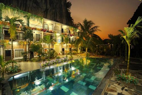 a large pool in front of a building at night at Tam Coc Green Haven Retreat in Ninh Binh