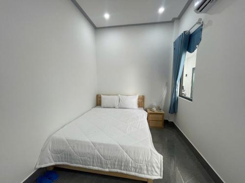 a small bedroom with a white bed in it at Nhà Nghỉ Dragon in Cao Lãnh