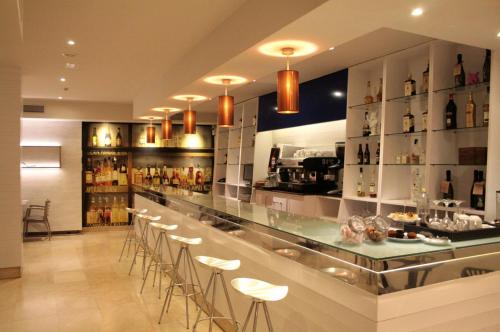 a bar in a restaurant with stools at Hotel Alda San Carlos in Santiago de Compostela