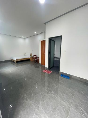 an empty room with a bed and a table at Nhà Nghỉ Dragon in Cao Lãnh