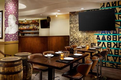 a restaurant with tables and chairs and a flat screen tv at Hotel Spero, Vignette Collection by IHG in San Francisco